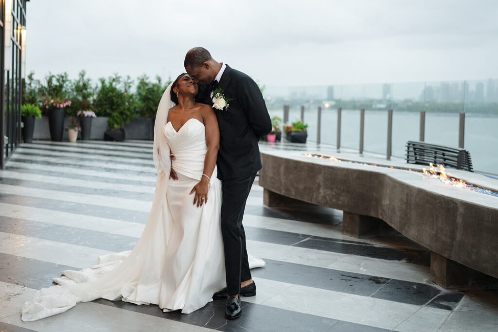 Couple taking a wedding photo at Hudson House New Jersey surrounded by water.